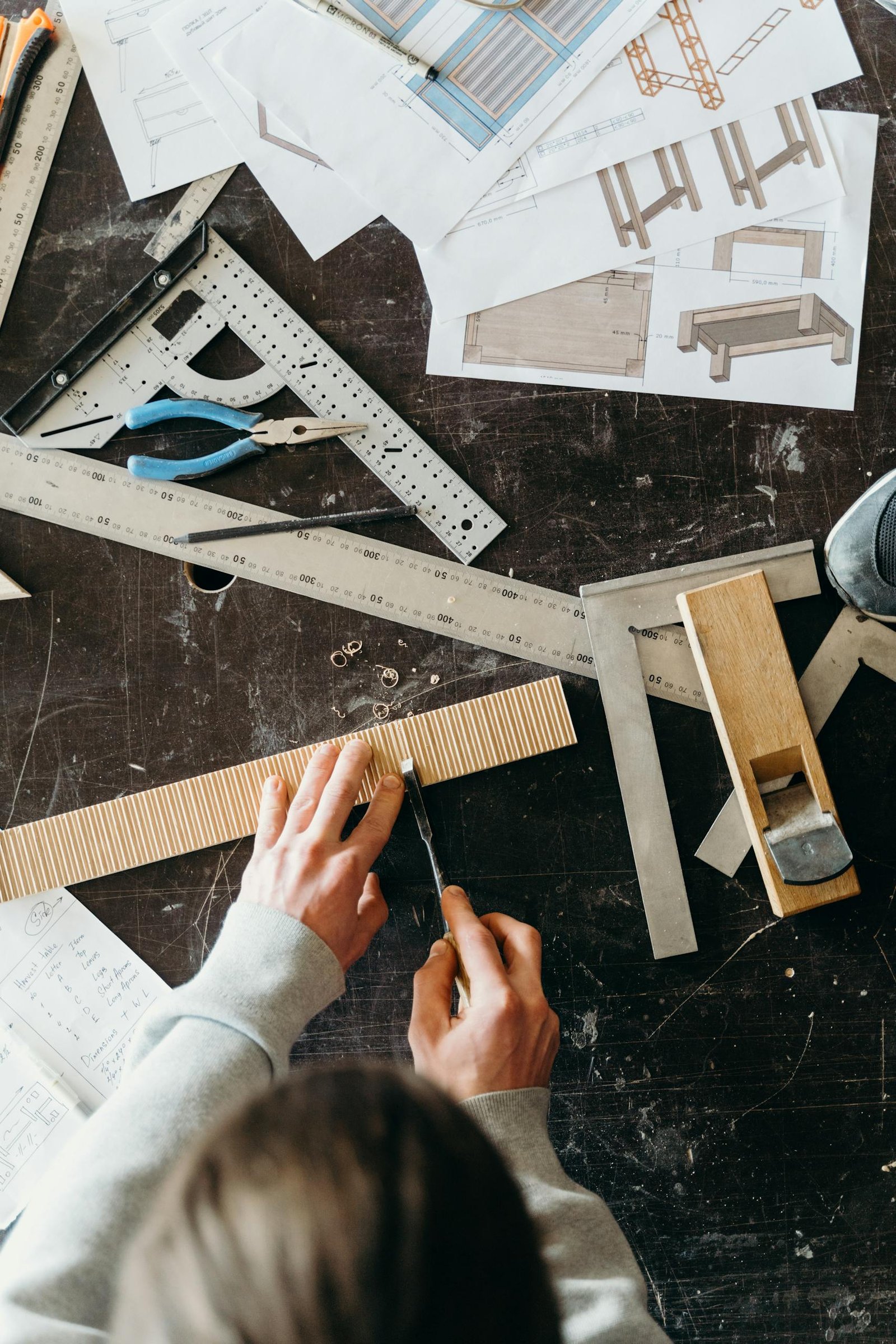 Fabricante trabajando con planos y herramientas