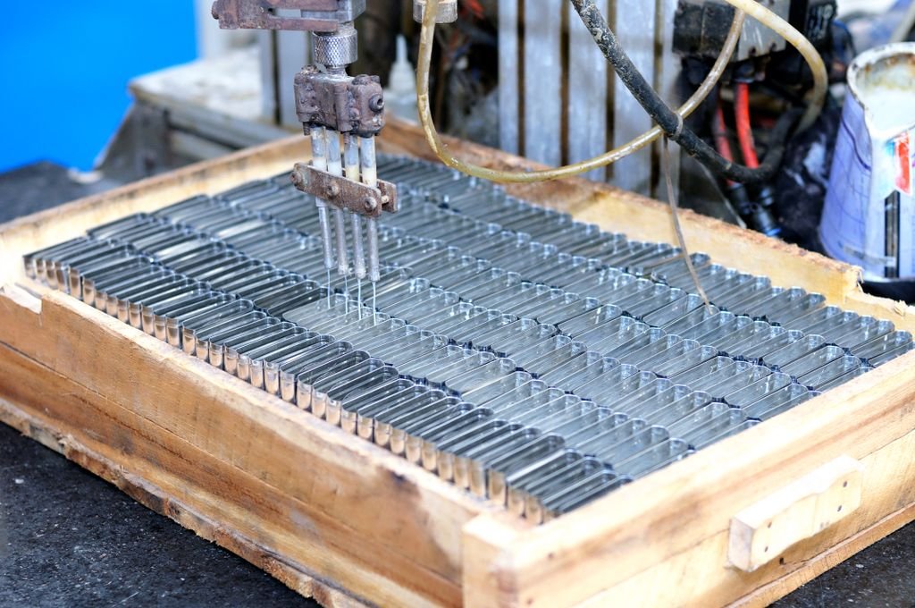 Máquina automatizada fabricando piezas metálicas en un entorno industrial.