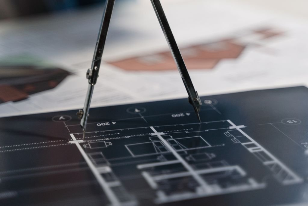 Plano técnico con compás para comparar alternativas en una matriz de decisión.