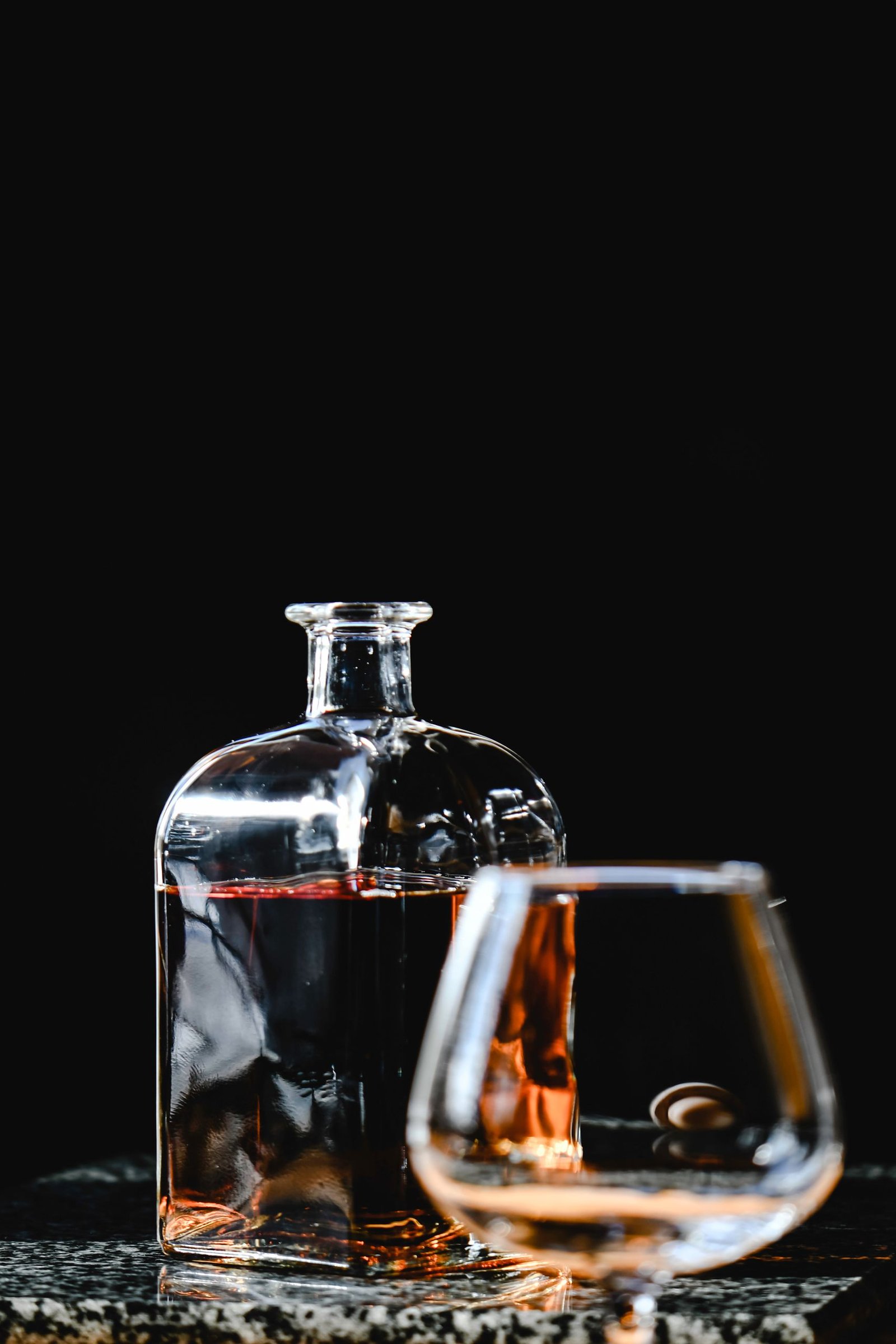 Botella y copa sobre fondo oscuro como referencia para un kit de bebidas