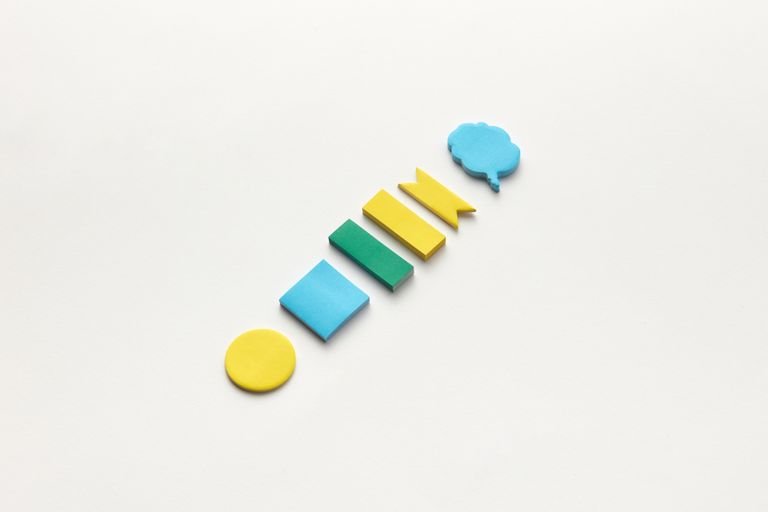 Colorful sticky notes arranged on a white surface, perfect for school and office supplies theme.
